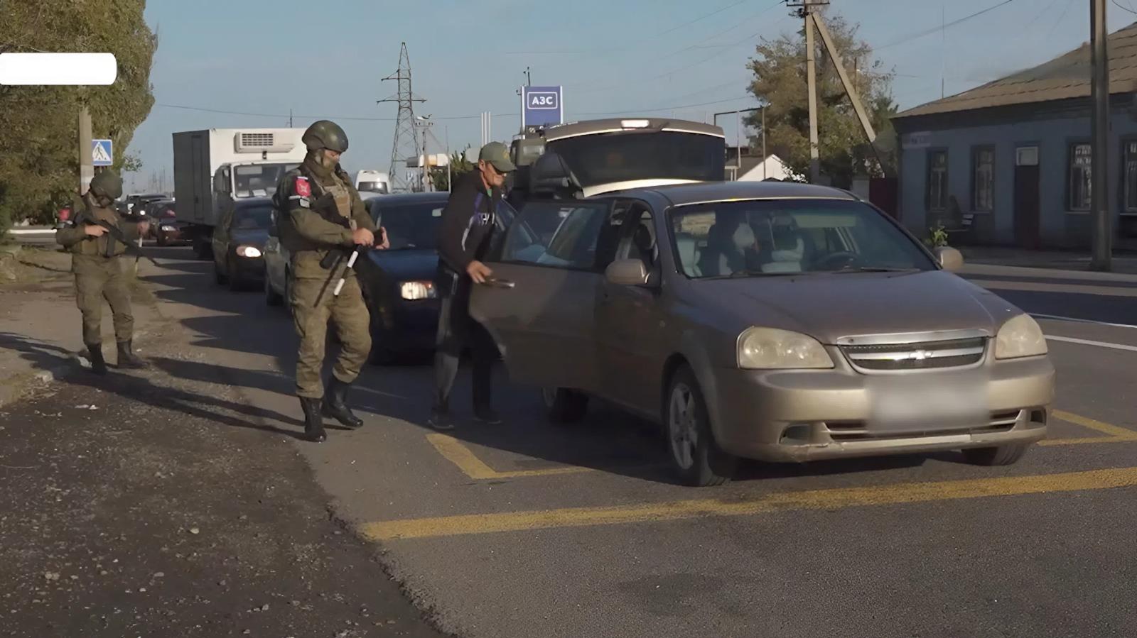 Військовий РФ перевіряє цивільну автівку на блокпості в окупованому Генічеську на Херсонщині